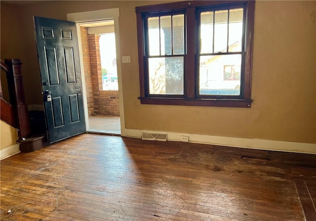 foyer with hardwood / wood-style floors, baseboards, and visible vents