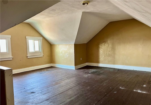 additional living space featuring vaulted ceiling, baseboards, and hardwood / wood-style floors