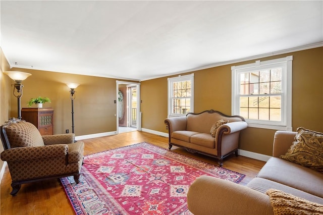 living room with crown molding, wood finished floors, and baseboards