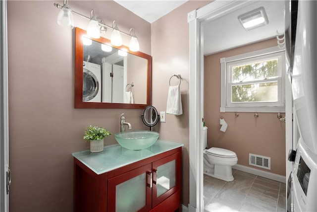 bathroom with vanity, baseboards, visible vents, tile patterned floors, and toilet