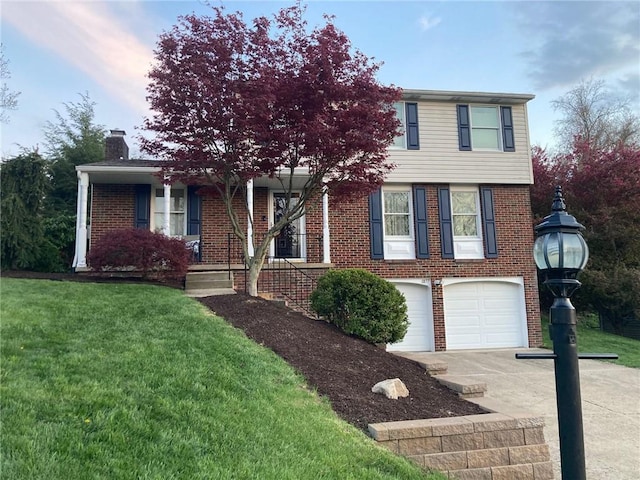 view of front of house featuring a front lawn, brick siding, concrete driveway, and a chimney