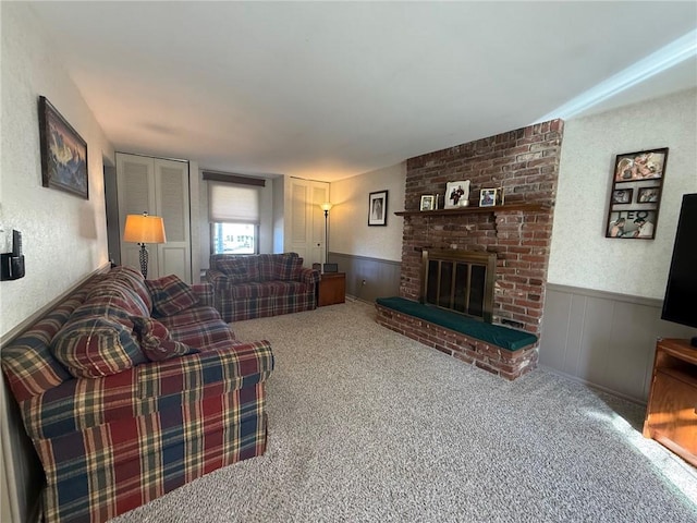 carpeted living room with wainscoting and a fireplace