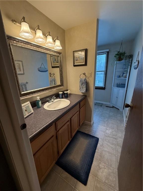 bathroom featuring baseboards, vanity, and tile patterned flooring