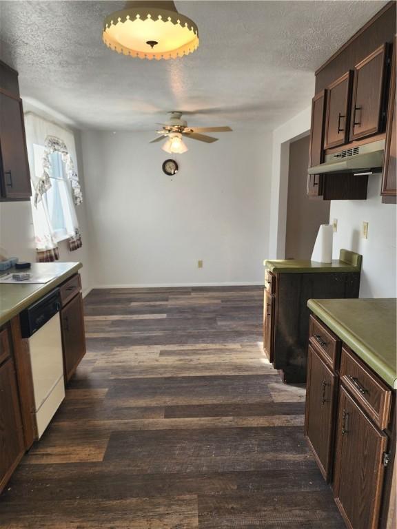 kitchen with dark wood-style floors, white dishwasher, under cabinet range hood, and a textured ceiling