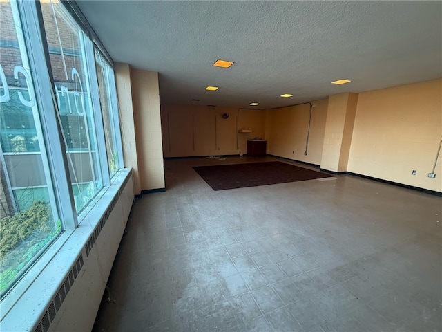 interior space featuring radiator, light floors, and a textured ceiling