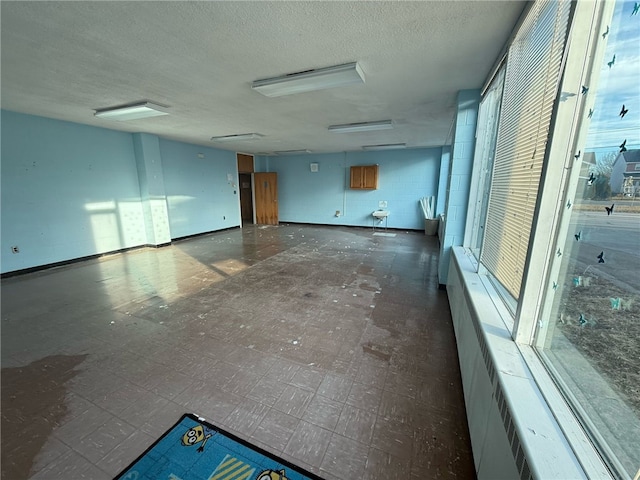 spare room featuring concrete block wall and a textured ceiling