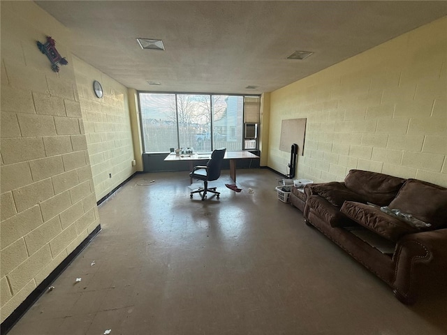 interior space with finished concrete flooring and concrete block wall