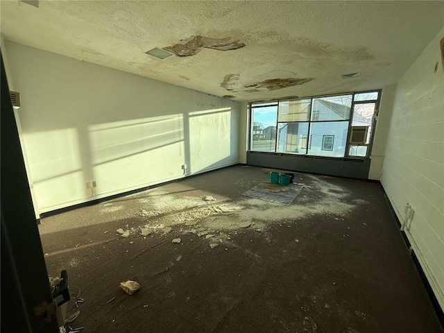 empty room featuring a textured ceiling and concrete block wall