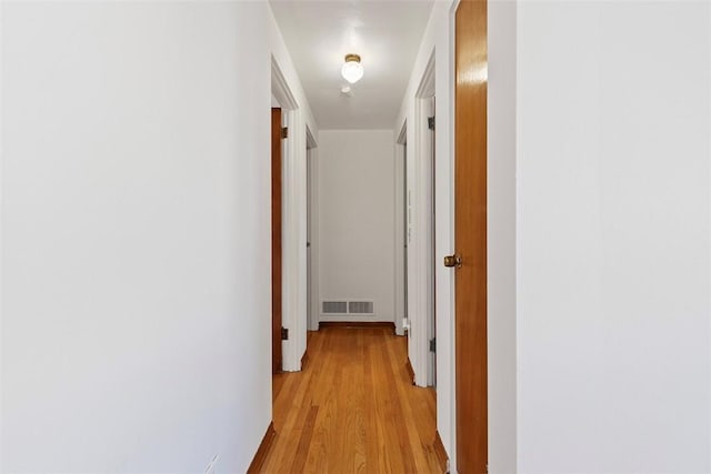 hallway featuring visible vents and light wood-style floors