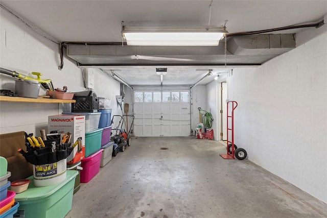 garage with a garage door opener and concrete block wall