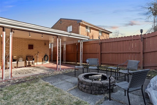 patio terrace at dusk with a fire pit and fence