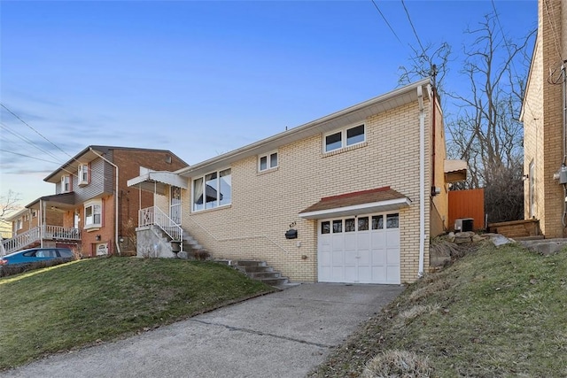 view of front of home featuring brick siding, a front lawn, central AC unit, driveway, and an attached garage