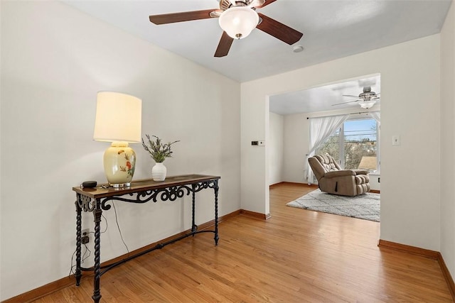 hall featuring baseboards and light wood-style floors