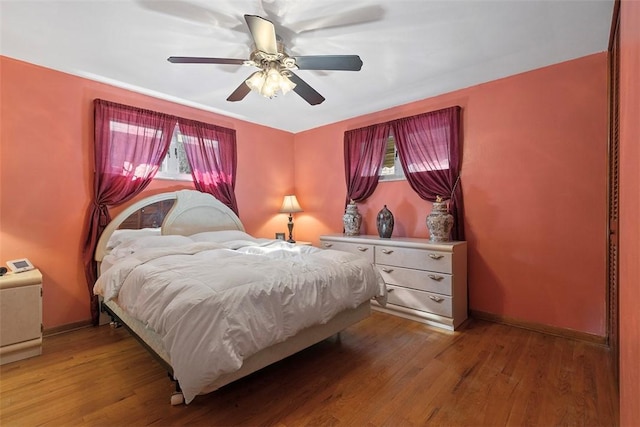 bedroom featuring light wood-type flooring, baseboards, and a ceiling fan