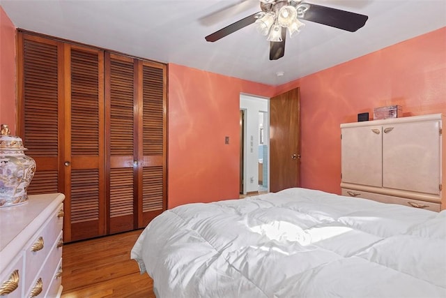 bedroom with a closet, light wood-style floors, and a ceiling fan