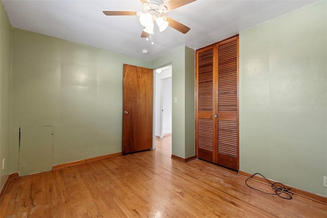 unfurnished bedroom with a closet, a ceiling fan, light wood-type flooring, and baseboards