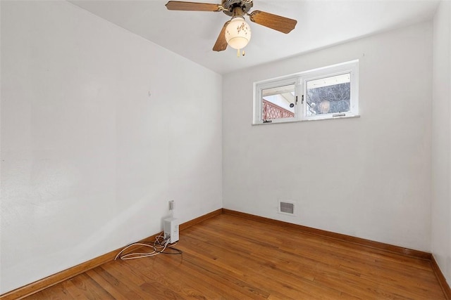 unfurnished room featuring visible vents, baseboards, wood finished floors, and a ceiling fan