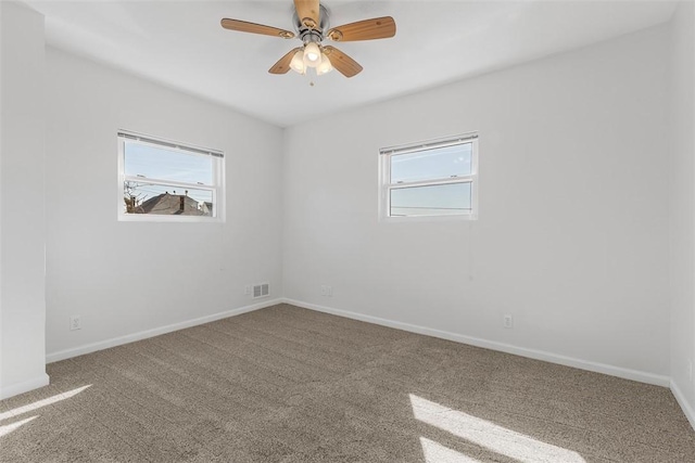 unfurnished room featuring visible vents, plenty of natural light, baseboards, and carpet flooring