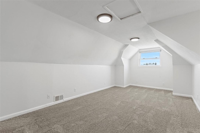 bonus room with carpet, visible vents, baseboards, attic access, and lofted ceiling