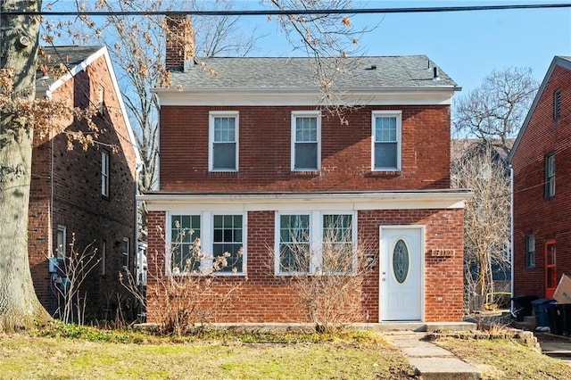 view of front of property featuring brick siding and a chimney