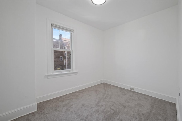 spare room with baseboards and carpet floors