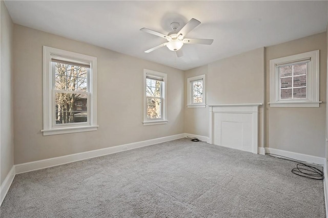 empty room featuring baseboards, ceiling fan, and carpet flooring