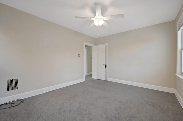 spare room with visible vents, baseboards, carpet, and a ceiling fan