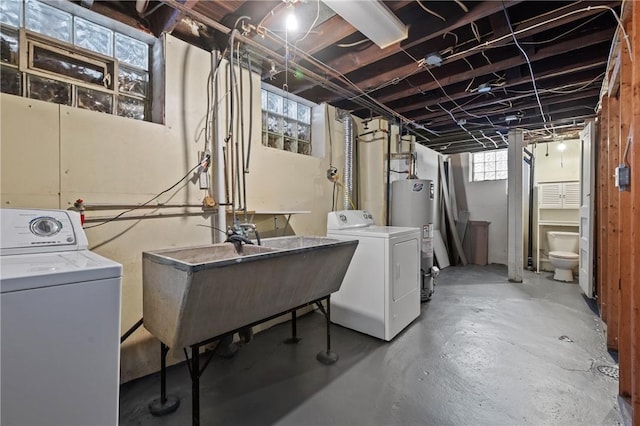 below grade area with a sink, water heater, and washing machine and clothes dryer