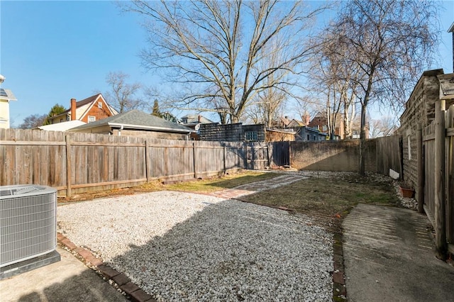 view of yard featuring a patio area, central air condition unit, and a fenced backyard