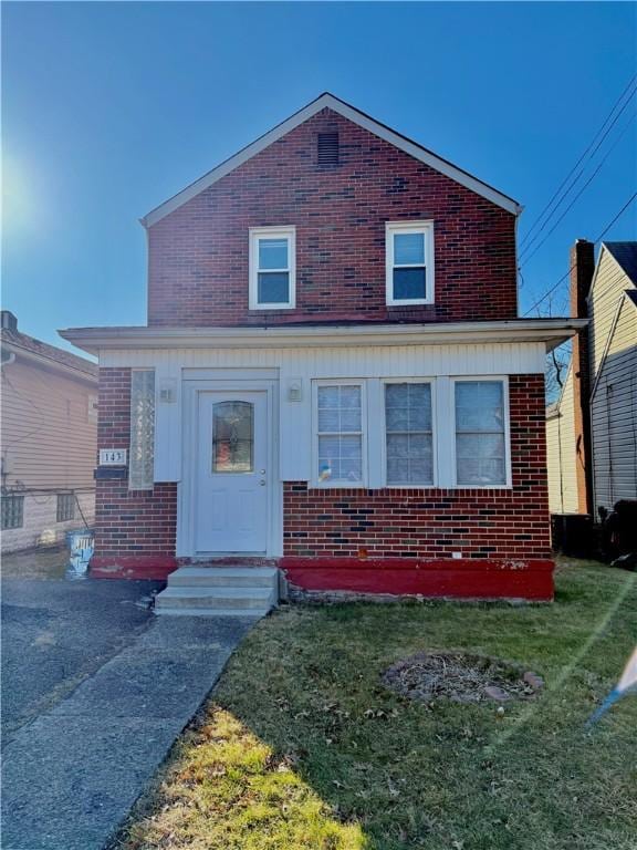 view of front of home featuring brick siding and a front lawn