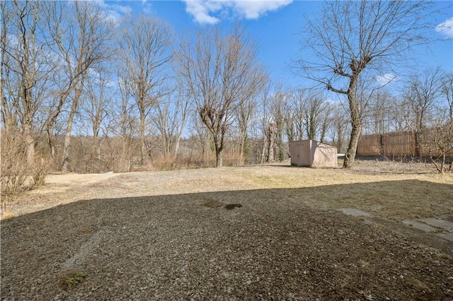 view of yard with an outbuilding, a storage shed, and fence