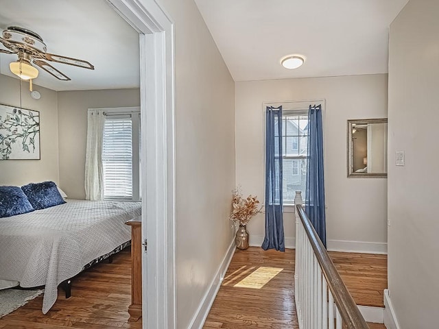 hallway with baseboards and wood finished floors