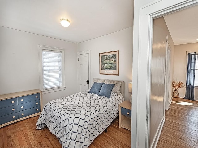 bedroom with multiple windows and wood finished floors