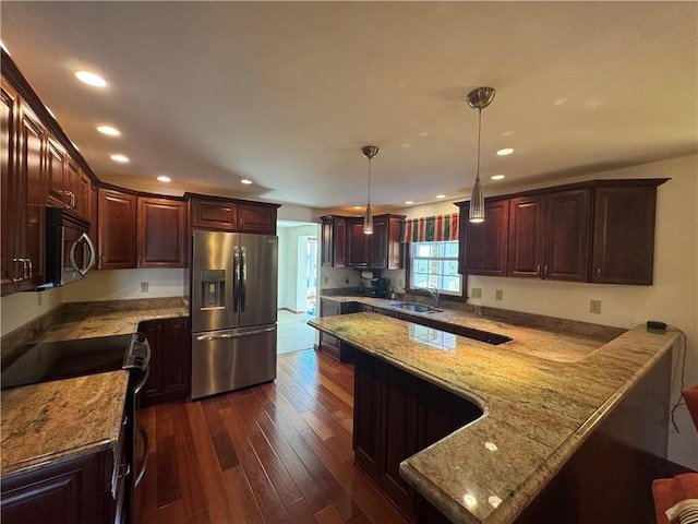 kitchen featuring light stone countertops, dark wood finished floors, a peninsula, stainless steel appliances, and a sink