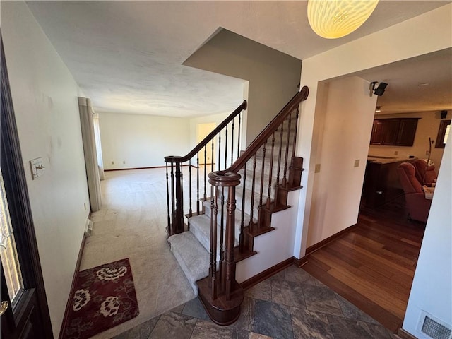 stairway featuring visible vents and baseboards