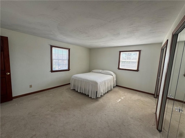 unfurnished bedroom with baseboards, multiple windows, and a textured ceiling