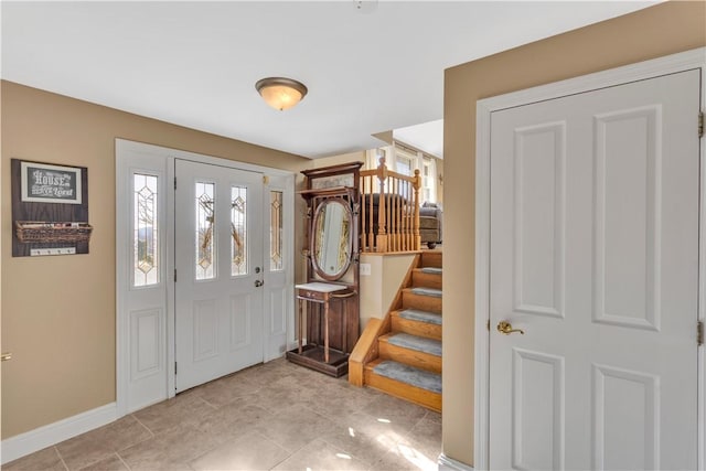 entrance foyer with stairs and baseboards