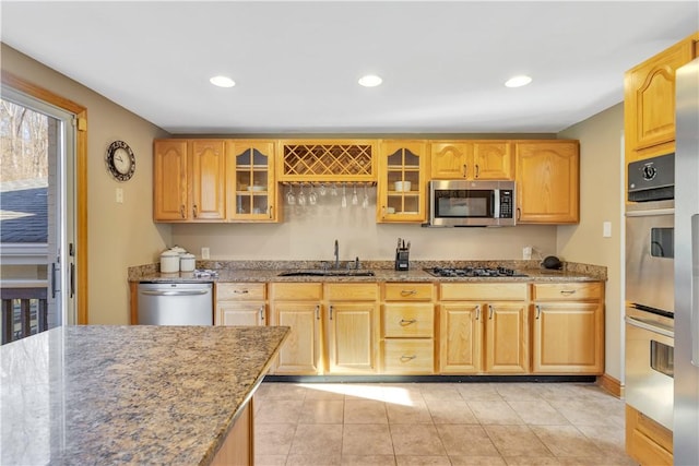 kitchen with glass insert cabinets, light stone countertops, recessed lighting, stainless steel appliances, and a sink