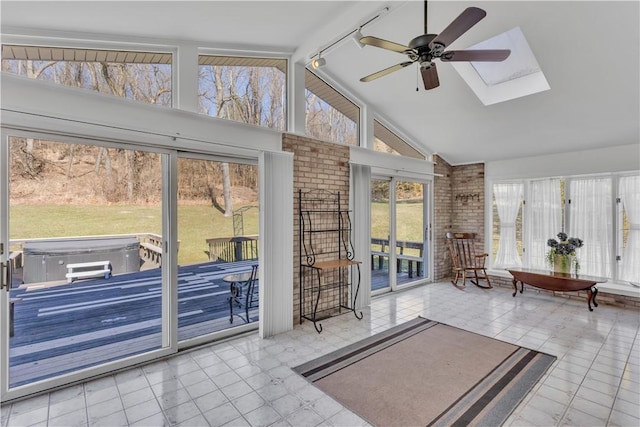 sunroom with lofted ceiling with skylight and a ceiling fan