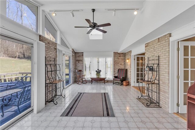 sunroom featuring vaulted ceiling, a healthy amount of sunlight, and ceiling fan