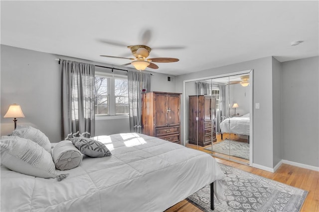 bedroom featuring visible vents, baseboards, wood finished floors, a closet, and a ceiling fan