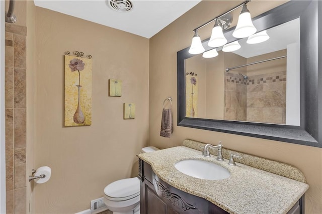 bathroom featuring visible vents, tiled shower, toilet, and vanity