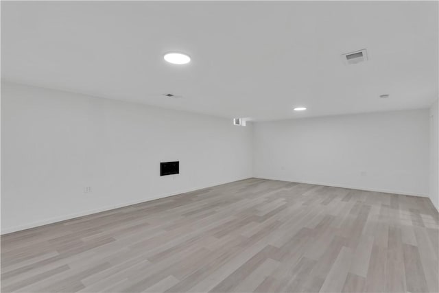 unfurnished room with baseboards, visible vents, and light wood-type flooring