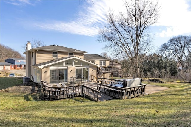 rear view of house featuring a deck, a yard, central AC, and a chimney