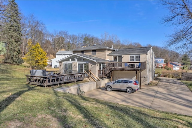 rear view of property with a wooden deck, driveway, a lawn, and an attached garage