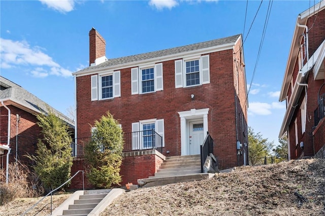 colonial-style house with brick siding and a chimney