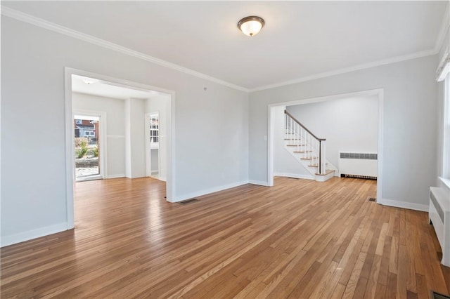 empty room with radiator heating unit, visible vents, light wood-type flooring, and ornamental molding