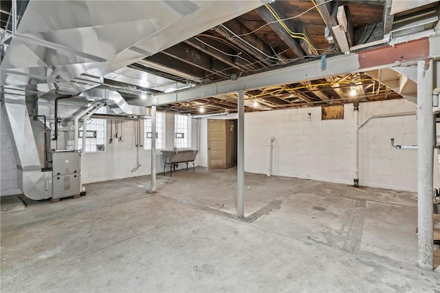 basement featuring heating unit and a sink