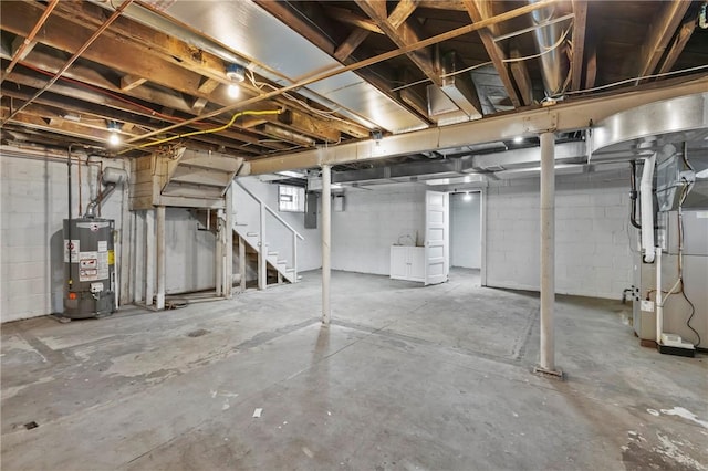 unfinished basement featuring heating unit and water heater