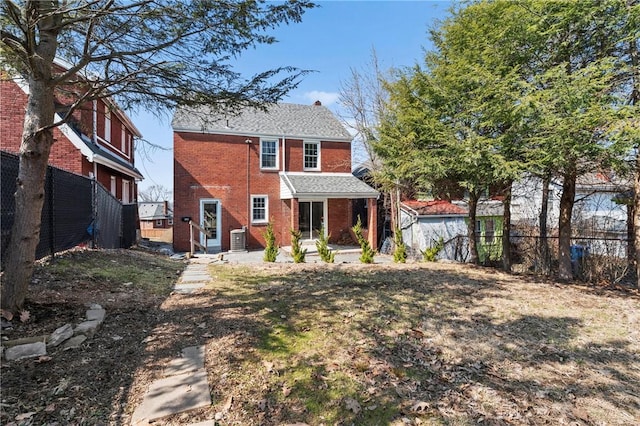 rear view of property featuring central air condition unit, brick siding, and fence